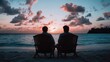 © Pinklife - Two people sit side by side in their chairs, silhouetted against a breathtaking sunset, creating a peaceful moment of companionship on the beach at dusk.