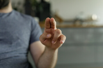 Aufkleber - Close-up of a man's hand making a gesture, indoors, blurred background.
