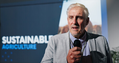 Poster - Microphone, seminar and speech with business man in auditorium for sustainable agriculture. Development, presentation and symposium with mature speaker on podium or stage for farming conference