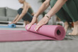 © zphoto83 - Yoga practitioners prepare their mats for a calming session in a bright indoor space during the morning hours