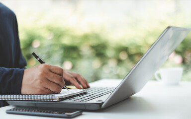 Poster - Freelancer lifestyle with hand writing notes while typing on laptop computer for online freelance work and project planning notebook. Digital freelance job, remote work, computer task, work from home.
