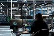 © DC Studio - Data center engineer uses AI visual programming to oversee automated repetitive tasks minimizing manual intervention. Worker adapting server systems based on data analytics graphs