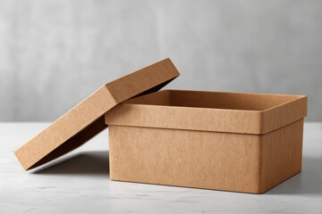 Poster - An open cardboard box with a separate lid, placed on a grey marble surface, ready to be filled with various items, offering a clean and simple aesthetic appeal.