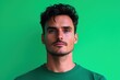 © WM7 - A captivating portrait of a young man, his intense gaze and serious expression highlighted against a vibrant green backdrop. The image showcases his stylish hair, well-groomed bear