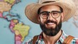 © PaulShlykov - Smiling man with a beard wearing glasses and a straw hat in front of a world map