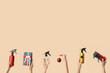 © Pixel-Shot - Hands holding bottles of hair spray and Christmas decorations on beige background