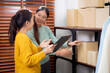 © NT_studio - Two young asian woman checking stock clothes for delivery in office, seller or entrepreneur checking and planning writing on document with inventory, online seller, small business and shipping.