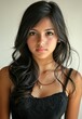 © sambath - A young woman with long, dark hair, wearing a black top, standing in front of a plain background.