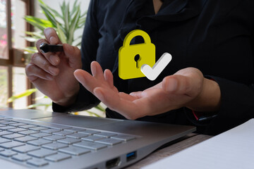 Poster - A person raises their hand with their palm open, and on the back there is a yellow security lock icon and a white check mark symbol, in front of a laptop screen.