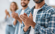 © praewpailyn - Happy group of people clapping hands in work environment celebrating anniversary with smiles and positive energy showing appreciation and support for success