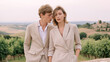 © dinatychynska - Stylish young couple in neutral outfits posing outdoors in scenic countryside. Summer fashion, romance, elegance, vacation and timeless minimalism in warm soft light.