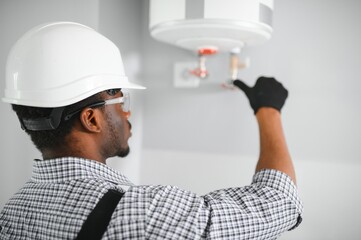 Poster - Young African Male Plumber Repairing Boiler
