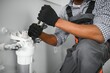 © Serhii - African american plumber change the water filter.