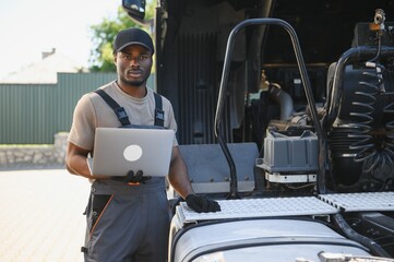 Aufkleber - Truck repair service. African american Mechanic makes computer diagnostic of the semitruck