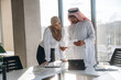 © standret - Big project, standing by table. Muslim man and woman are indoors in modern building