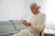 © standret - Grandma sits in a chair at home and knits clothes