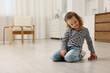 © New Africa - Little girl playing with toy car on floor at home, space for text
