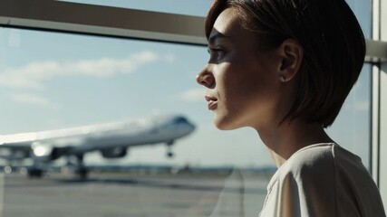 Aufkleber - Professional businesswoman standing near airport window, watching airplane taxiing on sunny runway, embodying global travel and career opportunity