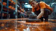 © Pinklife - A young man focuses on painting a factory floor, portraying dedication, precision, and the labor involved in ensuring a safe and visually appealing industrial environment.