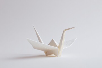 Poster - elegant origami crane resting gracefully on white surface with ample copy space