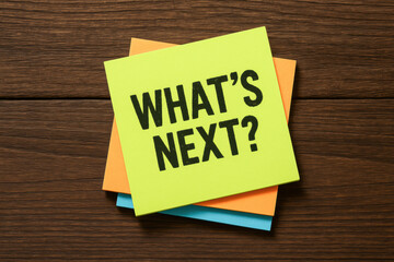 Poster - A lime green sticky note with a bold question prompts strategic thinking and future planning on a textured wooden surface