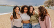 © PintoArt - Four young women embracing on beach, enjoying friendship and vacation