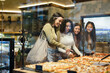 © PintoArt - Young women choosing pizza slices at shop window display