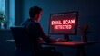 © LORD - A young Caucasian male in a suit sitting at a desk, focused on a computer screen displaying 'EMAIL SCAM DETECTED' in bright red.