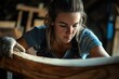 © imagepocket pro - A young woman meticulously crafts a wooden piece, showcasing dedication and skill in woodworking.