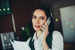 © deagreez - Confident businesswoman in office attire holding documents and talking on a smartphone in a professional workspace