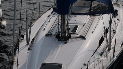 Poster - A white sailboat with a blue sail gliding across calm water, suitable for use in travel or leisure photography