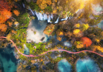 Wall Mural - aerial view of waterfall in vibrant autumn forest at sunrise. morning in plitvice lakes park, croati