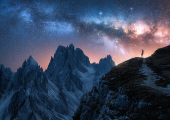 Wall Mural - glowing milky way and woman on mountain peak at starry night. tre cime, dolomites, italy. galaxy. sp