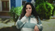 © Krakenimages.com - Woman with glasses surprised outdoors on street wearing striped sweater in daylight with trees in background, showcasing curious and expressive hispanic female reaction.