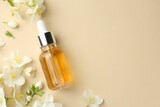 Essential oil and beautiful jasmine flowers on beige background, flat lay. Space for text