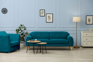 Poster - Stylish living room with comfortable sofa and light greyish blue wall. Interior design