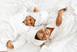 © Prostock-studio - Top View Of Happy Black Mother And Daughter In Bathrobes And Towels Lying On Bed Relaxing After Spa, Pampering Themself With Beauty Treatments At Home, Mom And Child Having Fun Together, Free Space