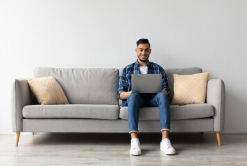 Aufkleber - Remote Work. Handsome Middle Eastern Freelancer Guy Working With Laptop At Home, Arab Millennial Man Sitting On Couch In Living Room And Using Computer, Enjoying Distance Job Opportunities, Copy Space