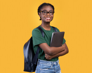 Aufkleber - Smiling African Female Student Holding Laptop Hugging Computer Posing Standing On Yellow Studio Background. E-Learning And Educational Gadgets, Distant Online Study And Student's Lifestyle Concept