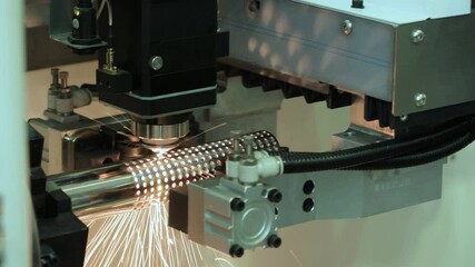 Poster - Automatic machine cuts holes in metal tube with laser and flame and sparks, industrial metal concept
