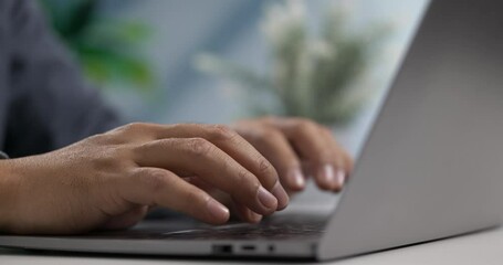Fototapete - Fingers typing on sleek laptop keyboard with soft daylight in modern workspace.