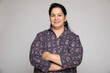 © Pix4Ads - Indian middle age woman wearing white shirt standing over isolated white background happy face smiling with crossed arms looking at camera