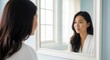 © phj.domingos - Woman looking in mirror at home reflects beauty and self care routine for healthy skin and wellness