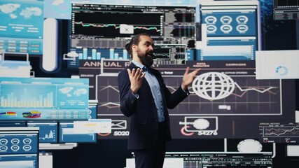 Poster - Professional businessman delivers inspiring business pitch on stage, using a hands free microphone. Visionary CEO and motivational speaker addresses attendees with charts and data. Camera B.