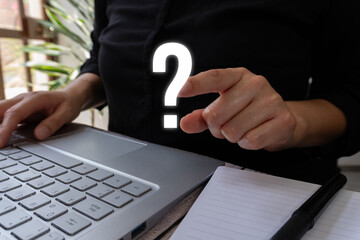 Poster - Close-up photograph of a woman's hand pointing at a question mark symbol on a laptop keyboard. 
