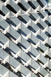 © yaqui_villegas - Geometric building facade with repetitive white balcony pattern, offering minimalism and structure in architectural detail with clean urban background