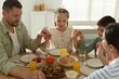 © New Africa - Family praying together before dinner at table indoors