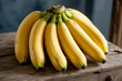 © sahera - Ripe Yellow Bananas Bunch on Rustic Wooden Surface