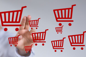Aufkleber - Image of hand interacting with multiple red shopping cart icons, symbolizing online shopping and e-commerce.