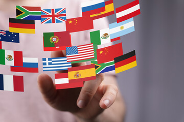 Poster - Image of a hand interacting with digital flags representing global communication and international relations.
